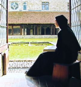 nun praying in the cloister